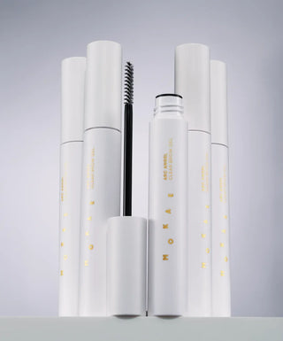Set of white cosmetic products with visible branding on a gray background