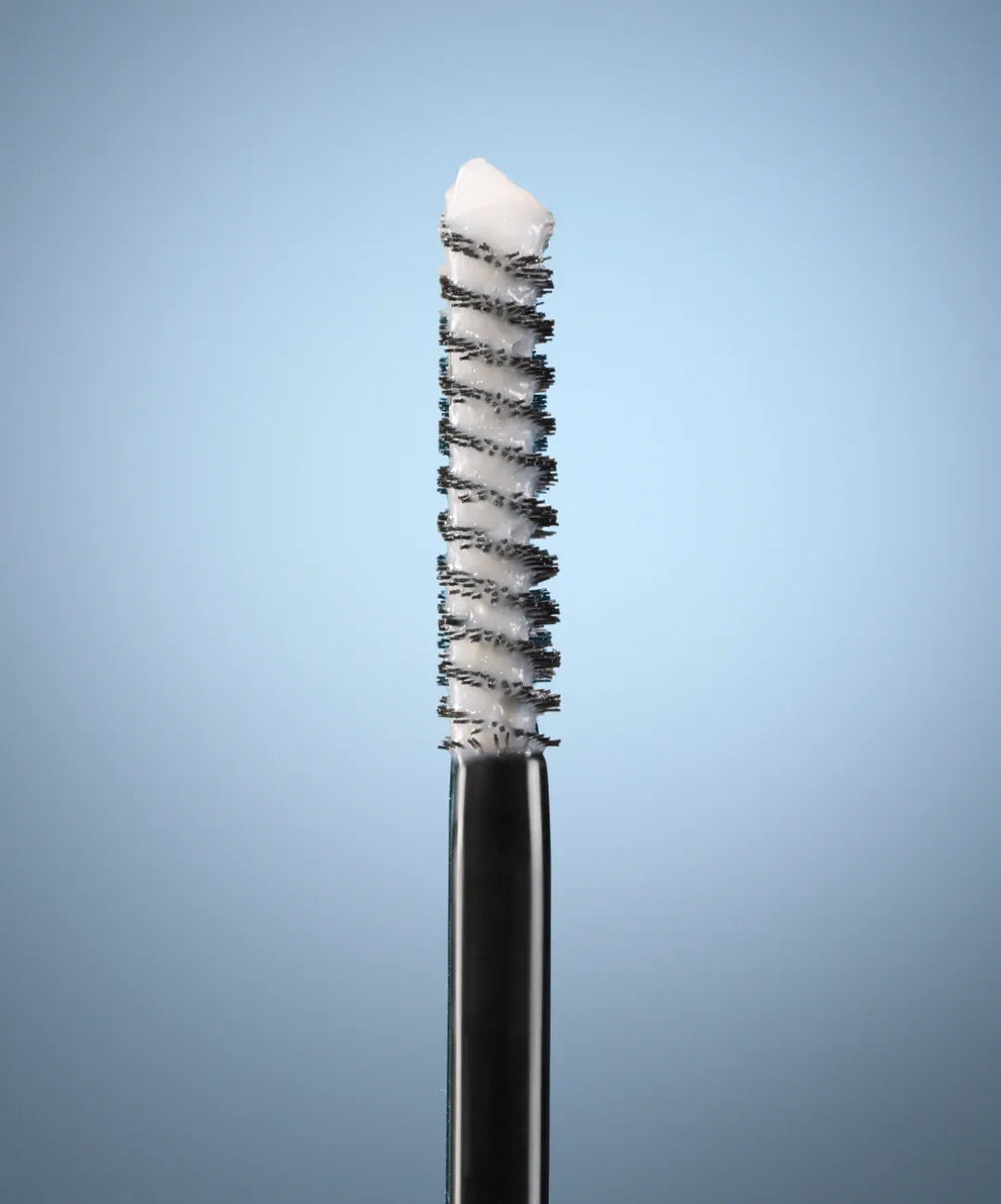 Eyebrow brush with bristle head on a gradient blue background