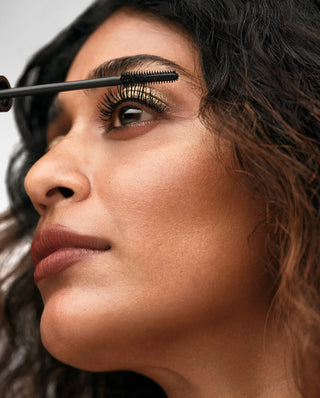 Woman applying mascara to her eyelashes with a brush